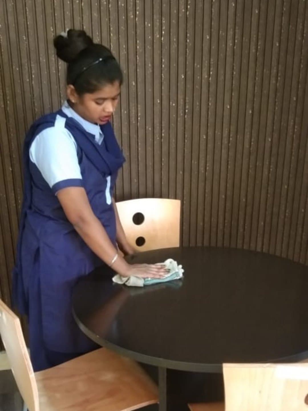 JIS housekeeping executive cleaning a meeting table